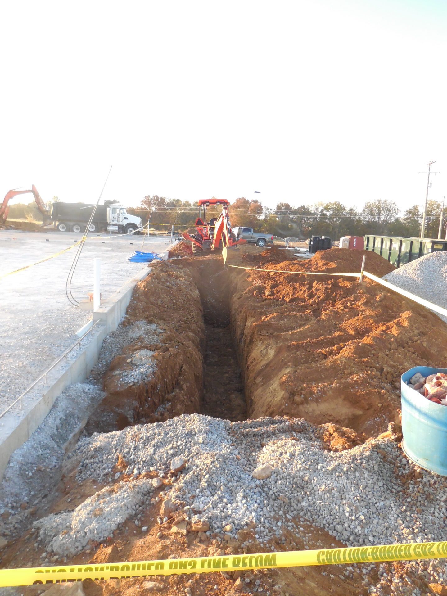 Construction site with an excavated trench, surrounded by caution tape